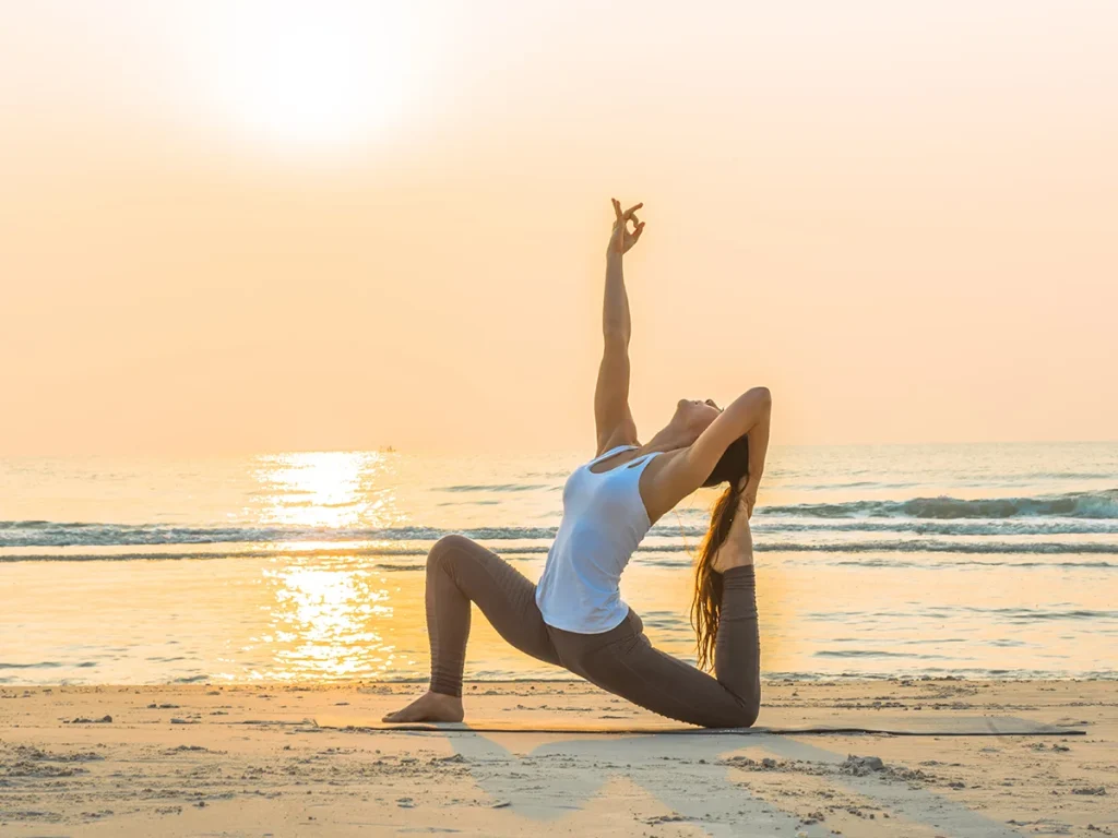 Image shows a person meditating or practicing yoga with serene surroundings, depicting a sunrise.